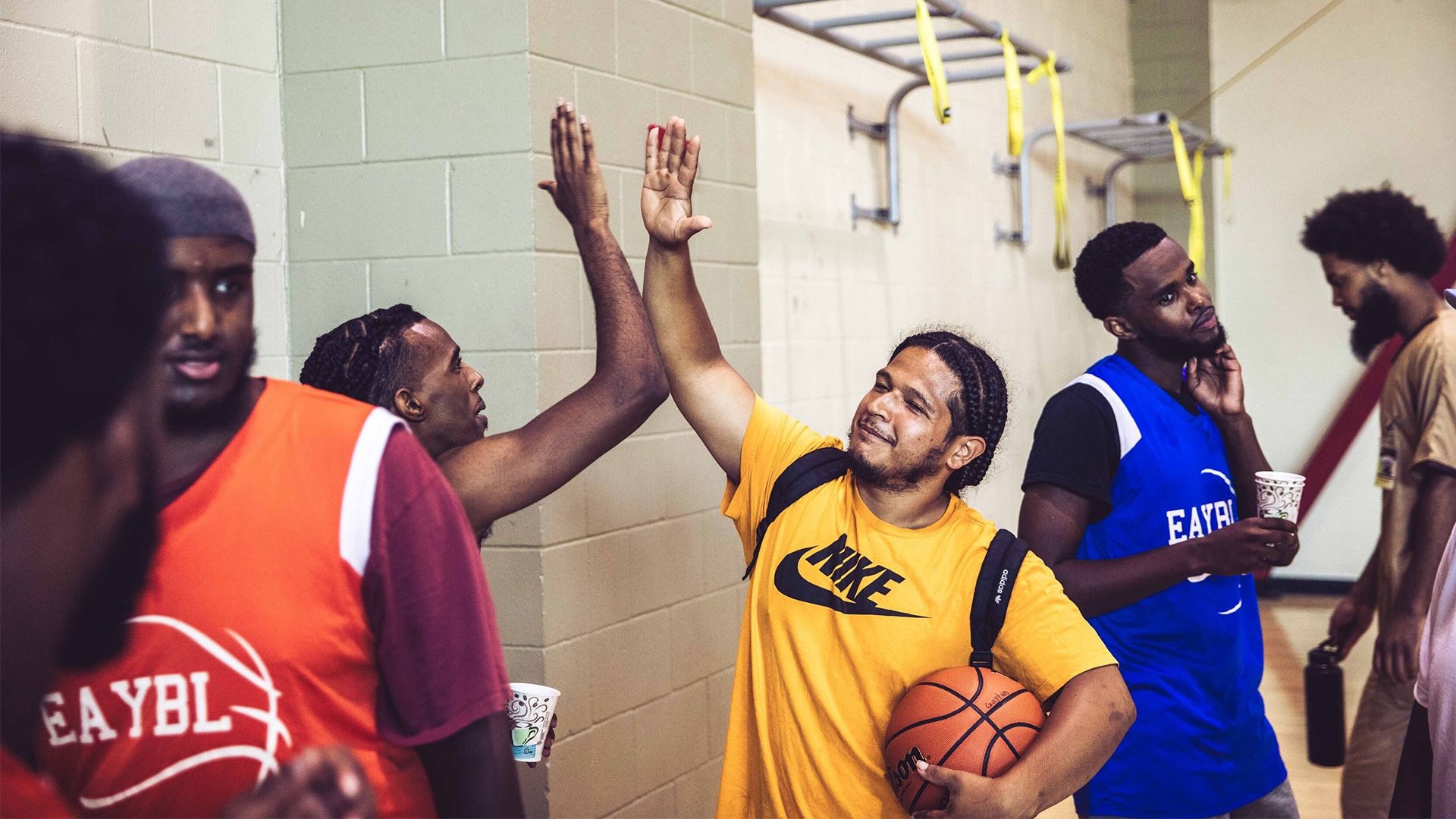 A group of young men high fiving in a locker room